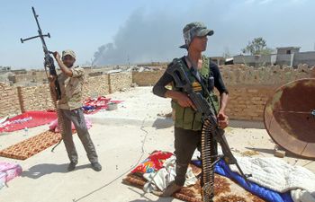 مقاتلان من قوات الحشد الشعبي يشاركان في عملية مع الجيش العراقي قرب بيجي بمحافظة صلاح الدين، في 25 ايار/مايو 2015