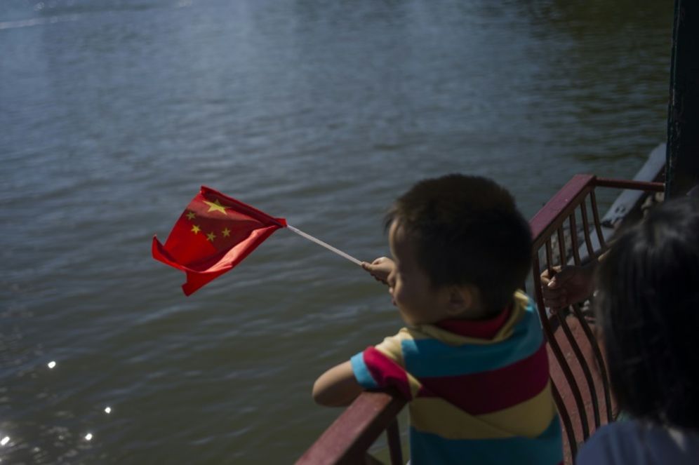 Fred Dufour (AFP/Archives) Un enfant tient un drapeau de la République populaire de Chine, en septembre 2015