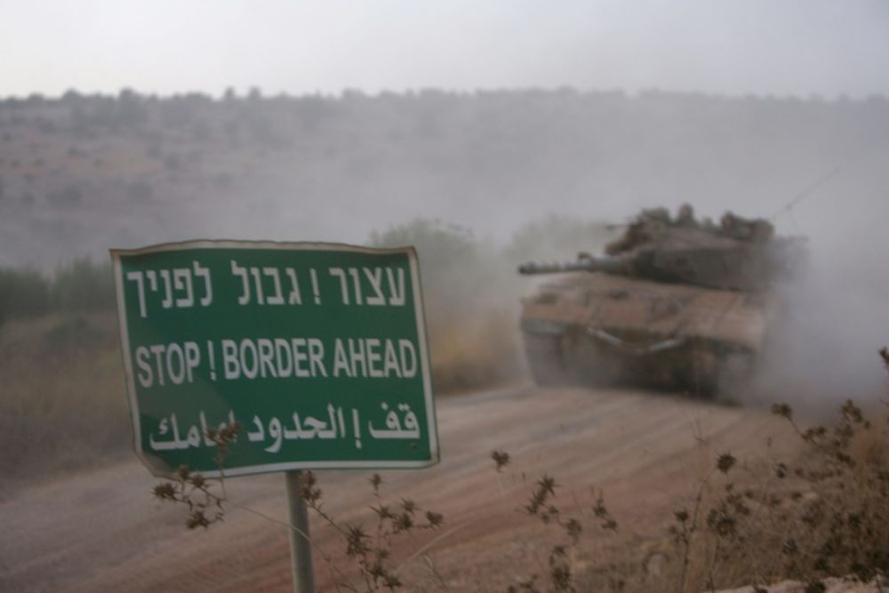 Israeli tanks are seen arriving at the Israel-Lebanon border, after returning from south Lebanon on August 16, 2006