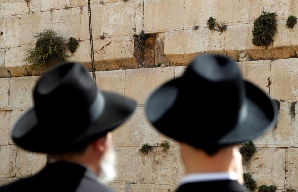 Orthodox Jewish men observe the gap left in the Western Wall on July 25, 2018, in Israeli-annexed east Jerusalem
