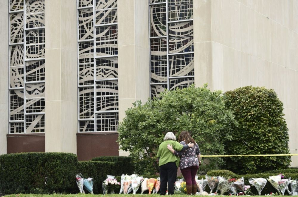 Des femmes s'embrassent devant des fleurs commémoratives, le 28 octobre 2018, devant la synagogue Tree of Life, théâtre de la pire attaque antisémite de l'histoire des États-Unis.