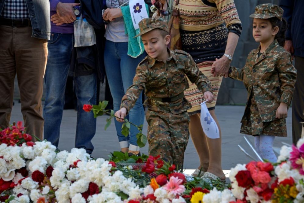 KAREN MINASYAN (AFP) Un jeune garçon en tenue militaire dépose le 24 avril 2018 à Erevan une fleur sur le mémorial dédié aux victimes du génocide arménien.