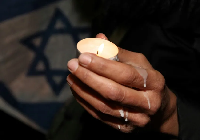 Illustration - Photo d'une bougie allumée devant un drapeau israélien