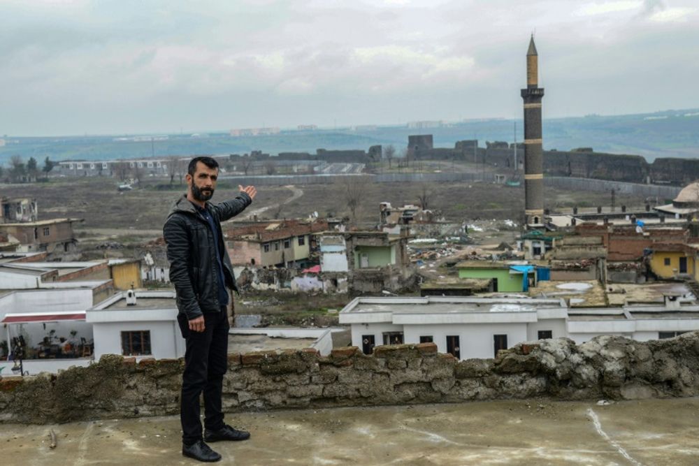 Metin Arslan, candidat aux élections locales, montre des immeubles endommagés dans le quartier de Sur à Diyarbakir, ville à majorité kurde, le 27 février 2019