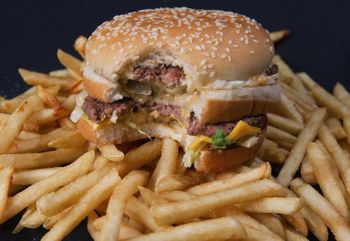 A partially eaten McDonald's Big Mac hamburger on top of some French fries on November 2, 2010