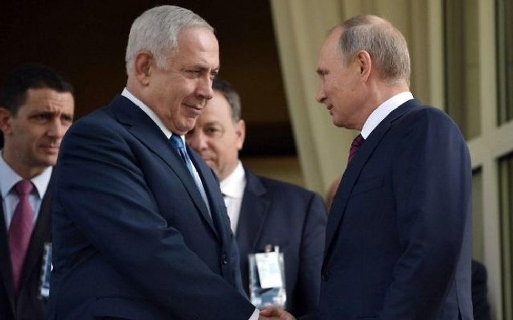Russian President Vladimir Putin (R) shakes hands with Prime Minister Benjamin Netanyahu during their meeting in Sochi on August 23, 2017.