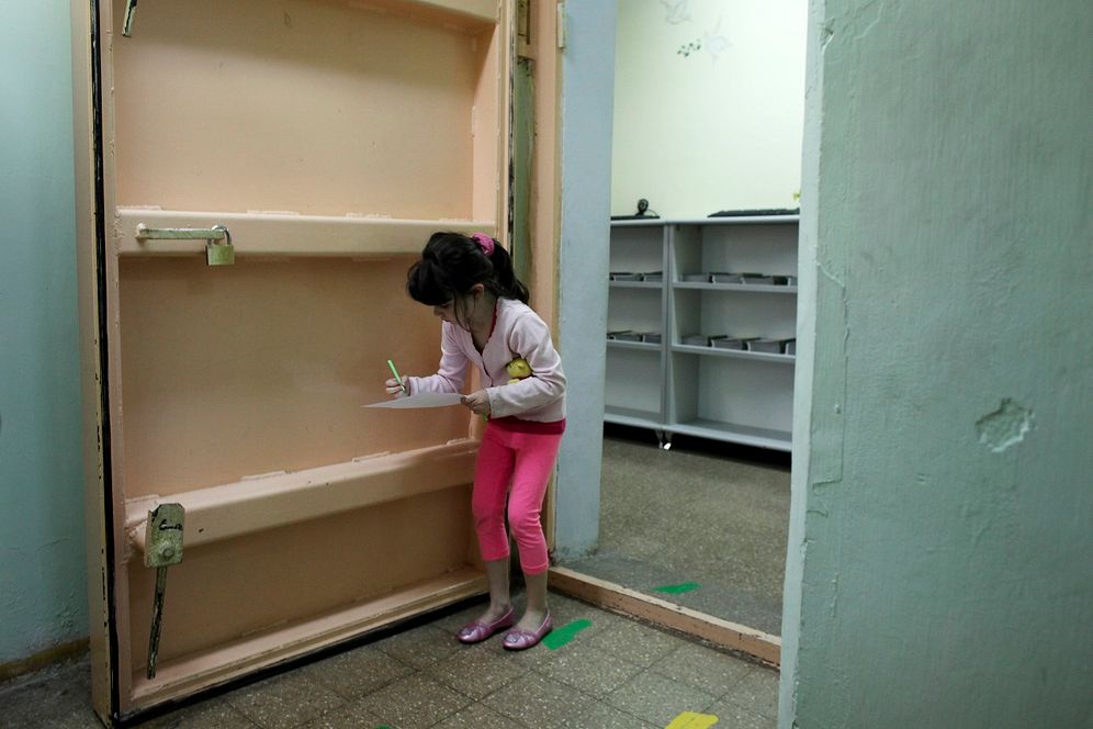 (AP Photo/Tara Todras-Whitehill) An Israeli girl attempts to write on a piece of paper as she leaves a bomb shelter after an air raid siren drill
