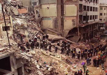 Firefighters and rescue workers search through the rubble of the Buenos Aires Jewish Community center in this July 18, 1994, file photo