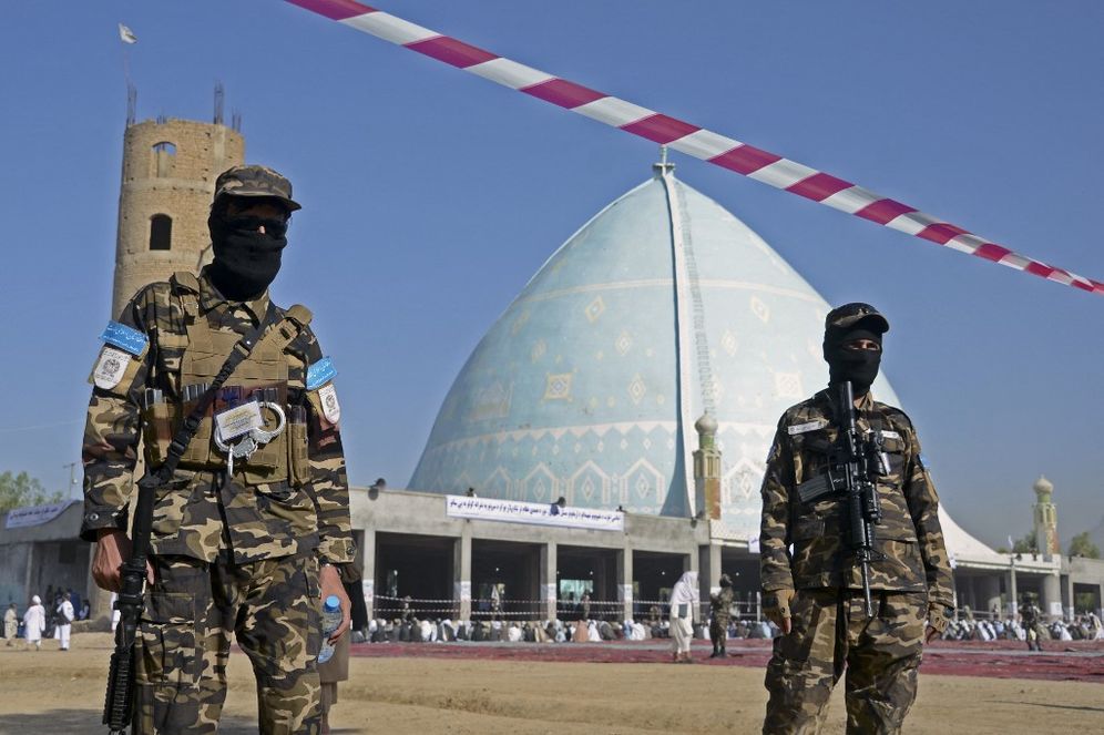 Taliban members stand guard at the Eidgah Mosque in Kandahar, Afghanistan, on May 1, 2022.