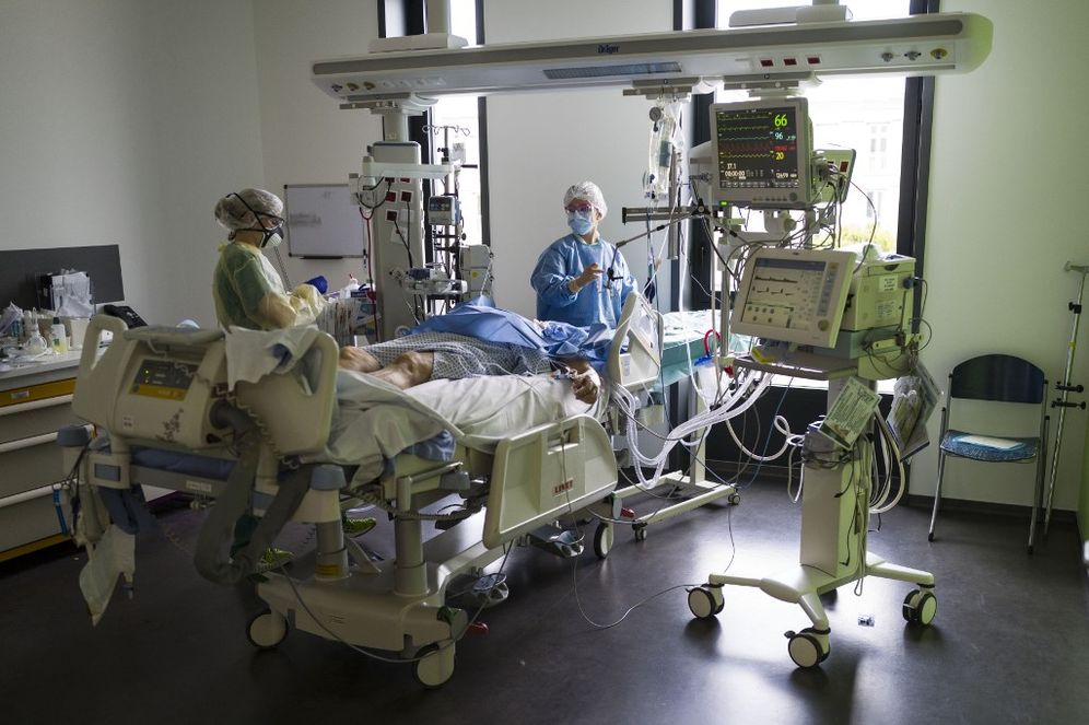 Le personnel médical travaille devant un patient dans une unité de soins intensifs de niveau pour les patients contaminés par un coronavirus COVID-19 de l'hôpital Louis Pasteur de Colmar, dans l'est de la France, le 26 mars 2020