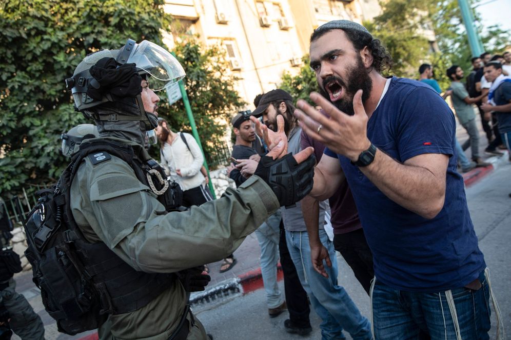Israeli riot police tries to block a Jewish man as clashes erupted between Arabs, police and Jews, in the mixed town of Lod, central Israel, May 12, 2021