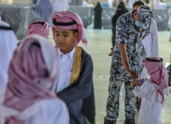 A member of the Saudi security forces helps a little boy in the holy city of Mecca, Saudi Arabia, on June 4, 2019.