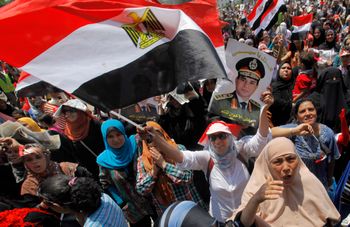 FILE- Opponents of Egypt's Islamist ousted president Mohammed Morsi wave national flags and a poster of Lt. Gen. Abdel-Fattah el-Sissi during a rally in Tahrir Square, in Cairo, Egypt, Friday, July 5, 2013.