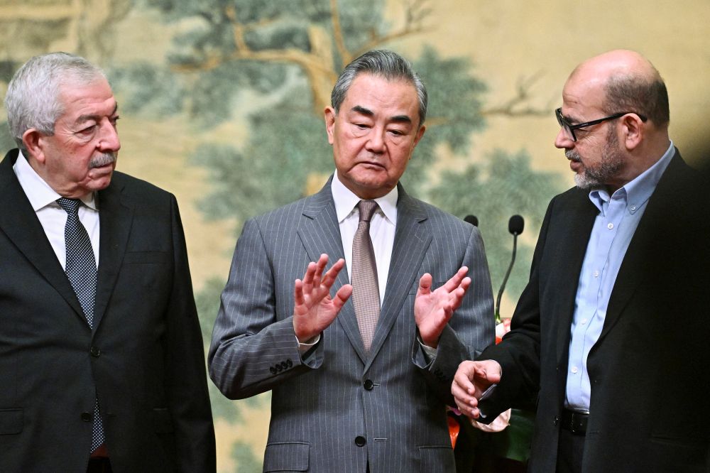 China's Foreign Minister Wang Yi (center) hosts an event for Mahmoud al-Aloul (left), vice chairman of Fatah, and Mussa Abu Marzuk, a senior member of Hamas, in Beijing, China