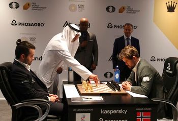 Sheikh Nahyan bin Mubarak Al Nahyan, UAE Minister of State for Tolerance, makes the starting move of game five between Norway's World Chess Champion Magnus Carlsen (R) and Ian Nepomniachtchi of Russia, during the FIDE World Championship in Dubai, United Arab Emirates, December 1, 2021.