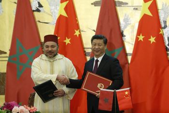 الرئيس الصيني شي جين بينغ (إلى اليمين) والملك المغربي محمد السادس يتصافحان بعد توقيع الوثائق خلال حفل التوقيع في قاعة الشعب الكبرى في بكين في 11 مايو 2016.