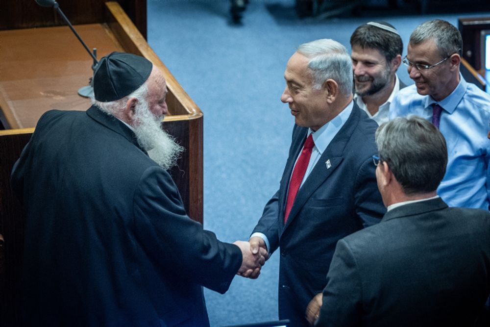 Yitzhak Goldknopf (L), Israel's Housing minister and leader of part of the ultra-Orthodox United Torah Judaism faction, shakes hands with Prime Minister Benjamin Netanyahu.