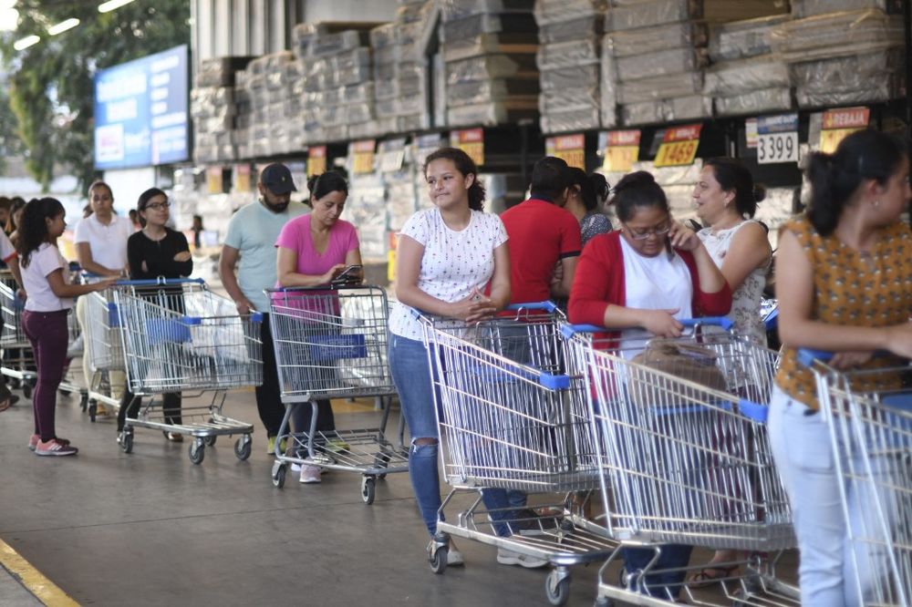 People wait for their turn to enter a supermarket in Guatemala City, Guatemala, on March 16, 2020.