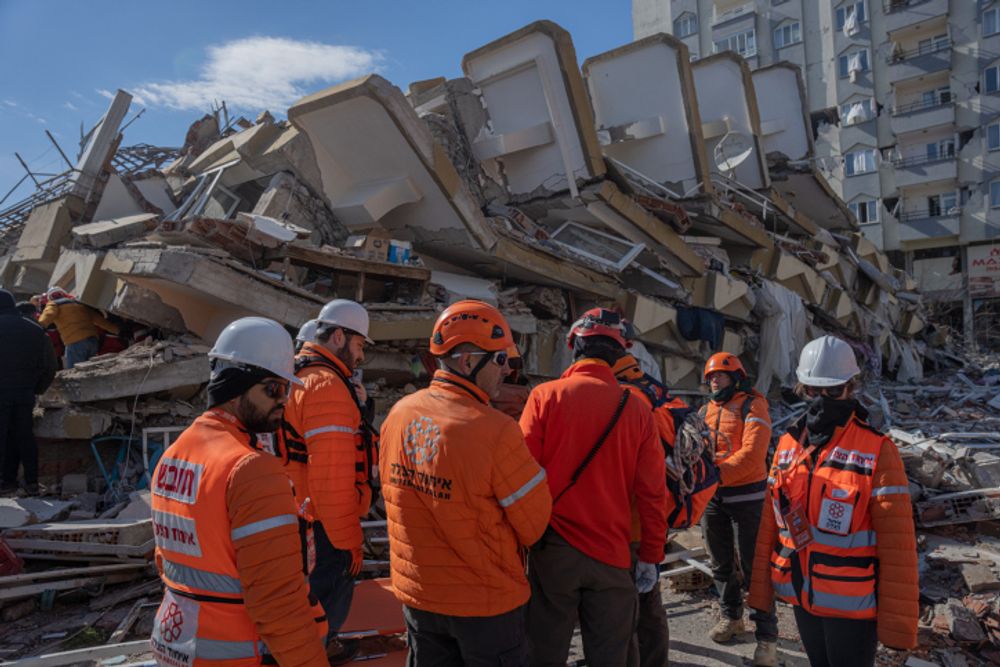 Des membres de l'organisation de services médicaux d'urgence United Hatzalah devant un bâtiment effondré après un tremblement de terre