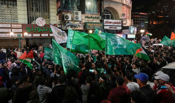 AP Photo/Majdi Mohammed) Des Palestiniens brandissent des drapeaux du Hamas alors qu'ils célèbrent la libération de prisonniers palestiniens à Naplouse, en Judée-Samarie, le 24 novembre 2023.