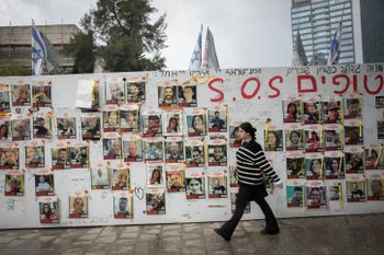 People walk by photographs of Israelis held hostage by Hamas terrorists in Gaza, at 'Hostages Square' in Tel Aviv.