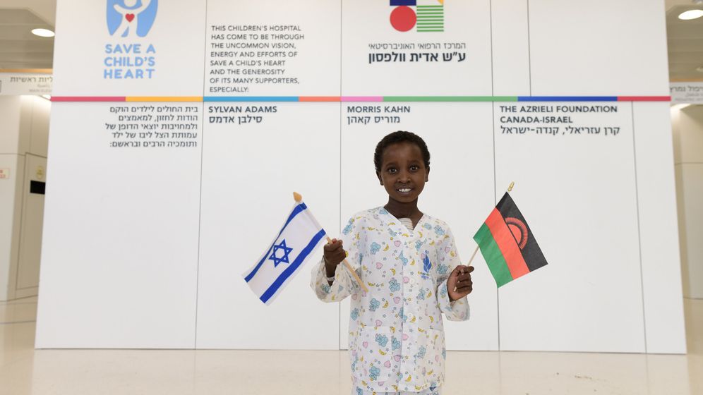 Miracle waves the Israeli and Malawian flags in the lobby of the Sylvan Adams Children’s Hospital 
