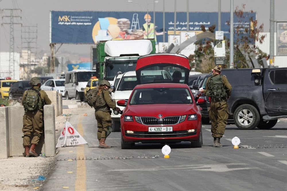 Israeli soldiers search a car at a checkpoint at the entrance of Jericho city in the West Bank.