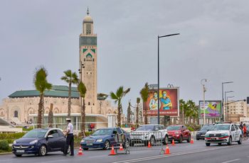 A Moroccan police officer controls a vehicle at checkpoint next to the Hassan II Mosque, Follow Medical Instructions in Casablanca, Morocco, Wednesday, Sept.23, 2020