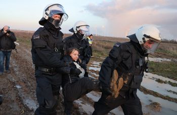 Police officers carry Swedish climate activist Greta Thunberg (C) out of a group of demonstrators and activists in Erkelenz, western Germany, on January 17, 2023.