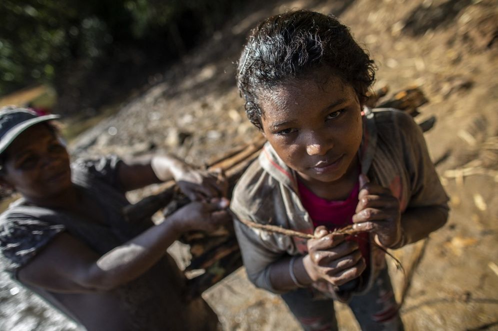 A Miskito indigenous woman arranges firewood for a girl to carry home in the community of Sangnilaya, Puerto Cabezas, North Caribbean Coast Autonomous Region of Nicaragua, on September 24, 2020.