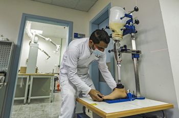 A medical worker adjusts a prosthetic limb at the Qatar-funded Sheikh Hamad Bin Khalifa Al-Thani rehabilitation center in Gaza on March 14, 2021.