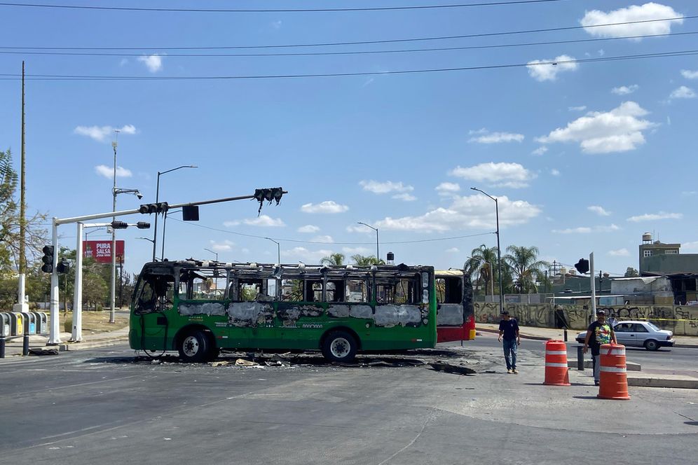Pedestrians walk past charred buses that were set on fire, on a road in Guadalajara, Jalisco state, Mexico, Sunday, Feb. 22, 2026, after the death of the leader of the Jalisco New Generation Cartel, Nemesio Rubén Oseguera Cervantes, known as "El Mencho."