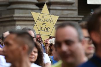 A protester holds a yellow star banner as protesters take part in a demonstration in Milan, Italy, on July 24, 2021.