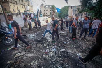 Palestinians cross a damaged road following an Israeli military raid to search for wanted Palestinians at the Nur Shams refugee camp, east of Tulkarm, in the West Bank
