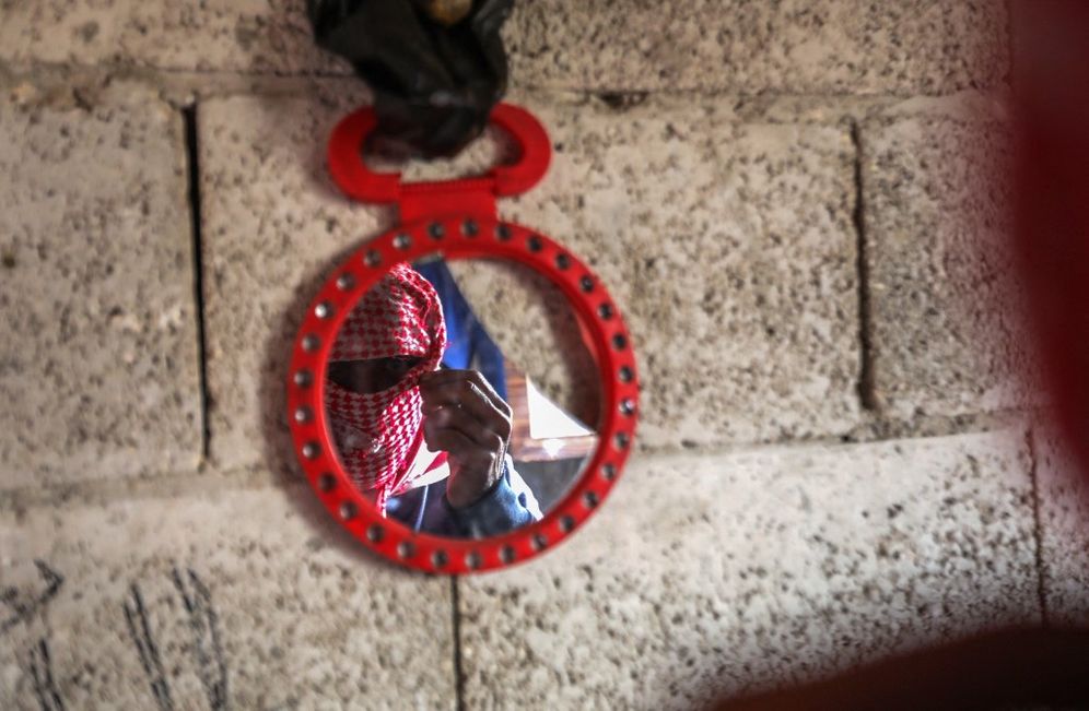 A Captagon dealer masks his face with a traditional keffiyeh scarf before sitting for an interview in the northern Syrian city of Aleppo, on April 26, 2022.