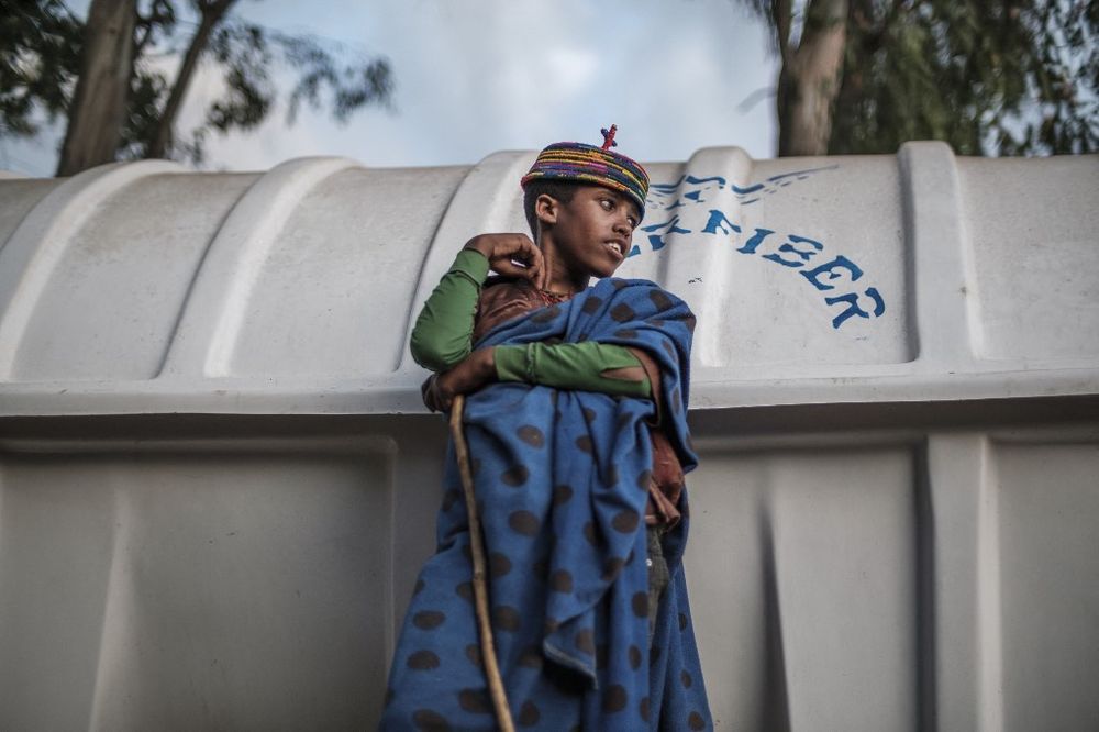A young boy next to a water tank the northern Amhara region bordering the northern region of Tigray, Ethiopia, on January 6, 2022.