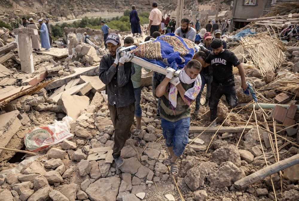 أشخاص يحملون رفات أحد ضحايا الزلزال المميت الذي وقع في 8 سبتمبر بقوة 6.8 درجة على مقياس ريختر، بالقرب من أمزميز، وسط المغرب.