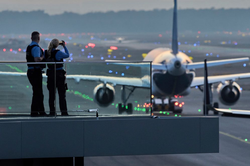 AP/Michael Probst) Police officers watch aircrafts take their parking positions at the airport in Frankfurt, Germany, Sunday, March 9, 2025, the evening before a warning strike of all major German airports.
