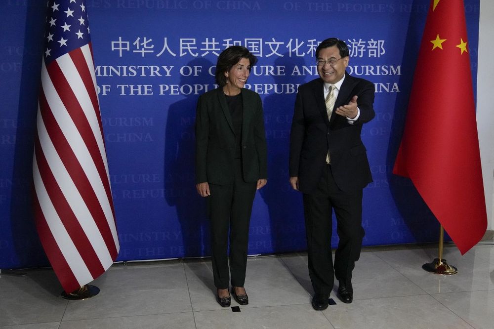 U.S. Commerce Secretary Gina Raimondo (L) is shown the way by Chinese Minister of Culture and Tourism Hu Heping before their meeting at the Ministry of Culture and Tourism in Beijing.