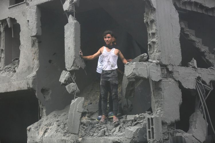 Des Palestiniens inspectent les dégâts causés aux bâtiments détruits à la suite des frappes aériennes israéliennes sur la ville de Gaza, le vendredi 27 octobre 2023.