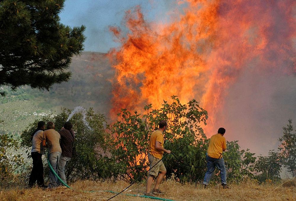 Locals try to extinguish a fire burning on the Mount Taygetus, in Kalamata, Greece, on August 24, 2007.