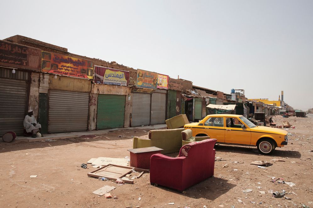 A man sits by shuttered shops in Khartoum, Sudan.