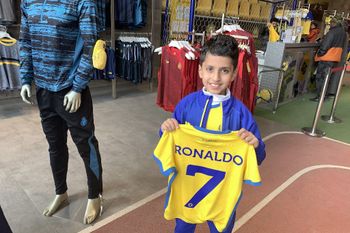 A young fan holds a shirt bearing the name Ronaldo and number 7, at the Saudi Al Nassr FC shop in the Saudi capital Riyadh.