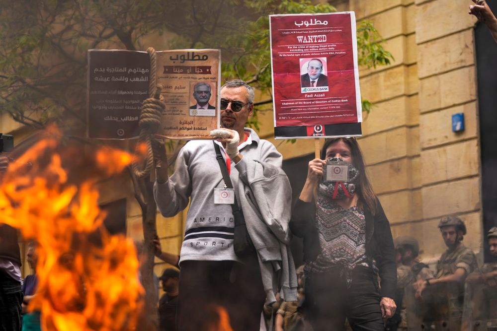 Protesting depositors carry placards criticizing bank owners for withholding their savings in Beirut, Lebanon.