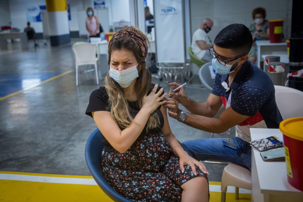 A pregnant woman recieves a Covid-19 vaccine at a Maccabi Health vaccination center in the Givatayim mall, outside of Tel Aviv, Israel.