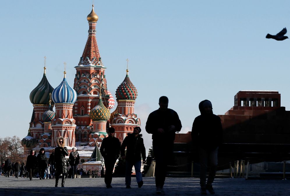 People walk along Red Square, with the Mausoleum of Soviet state founder Vladimir Lenin and St. Basil's Cathedral seen in the background, in central Moscow, Russia March 18, 2018