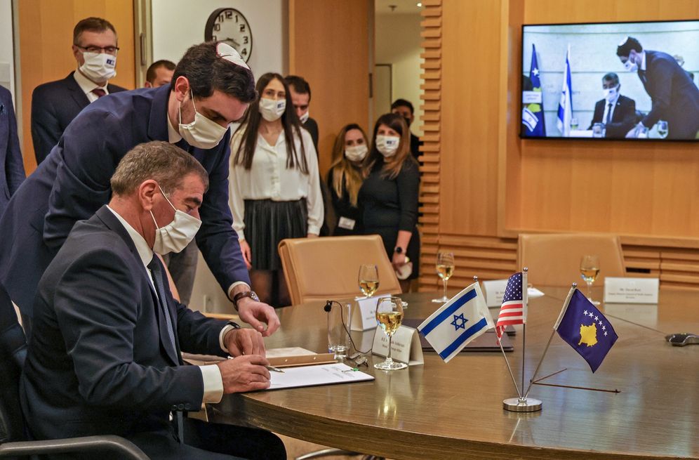 Israel's FM Gabi Ashkenazi (seated) signs a joint declaration establishing ties with Kosovo in an official ceremony held via Zoom at the Foreign Ministry in Jerusalem, on February 1, 2021.