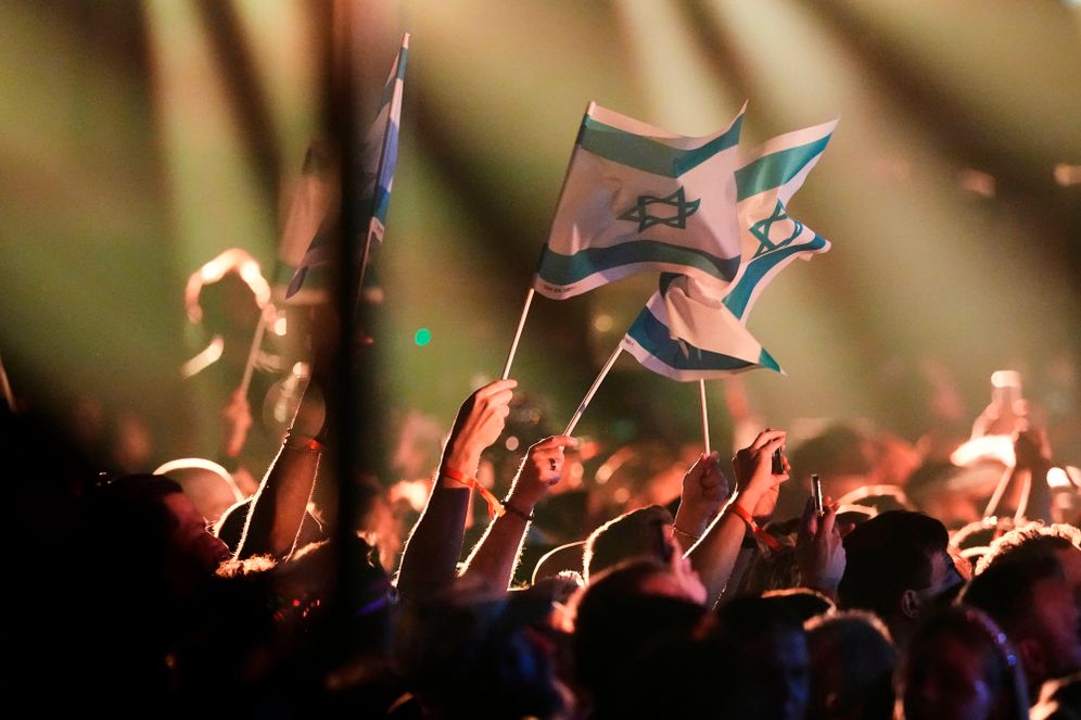 Israeli flags waved by members of the crowd as Noam Bettan from Israel performs the song "Michelle" during the first semifinal of the 70th Eurovision Song Contest in Vienna, Austria, Tuesday, May 12, 2026