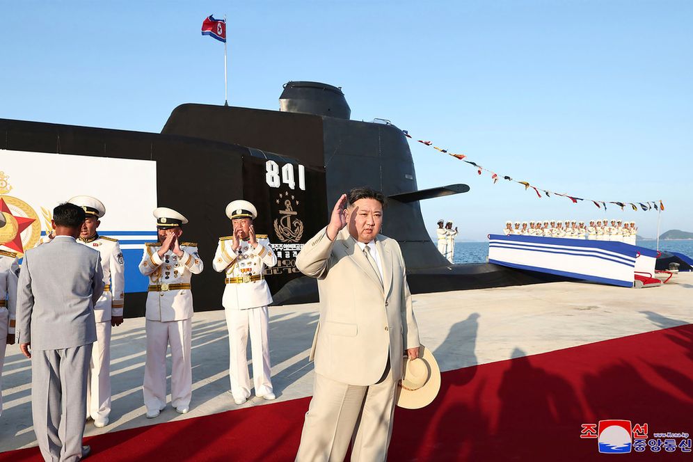In this photo provided by the North Korean government, North Korea leader Kim Jong Un, foreground, attends a launching ceremony of what is says a new nuclear attack submarine "Hero Kim Kun Ok" at an unspecified place in North Korea.