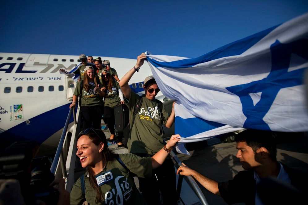 Des immigrants juifs brandissent un drapeau israélien à leur arrivée à l'aéroport Ben Gurion près de Tel Aviv, en Israël